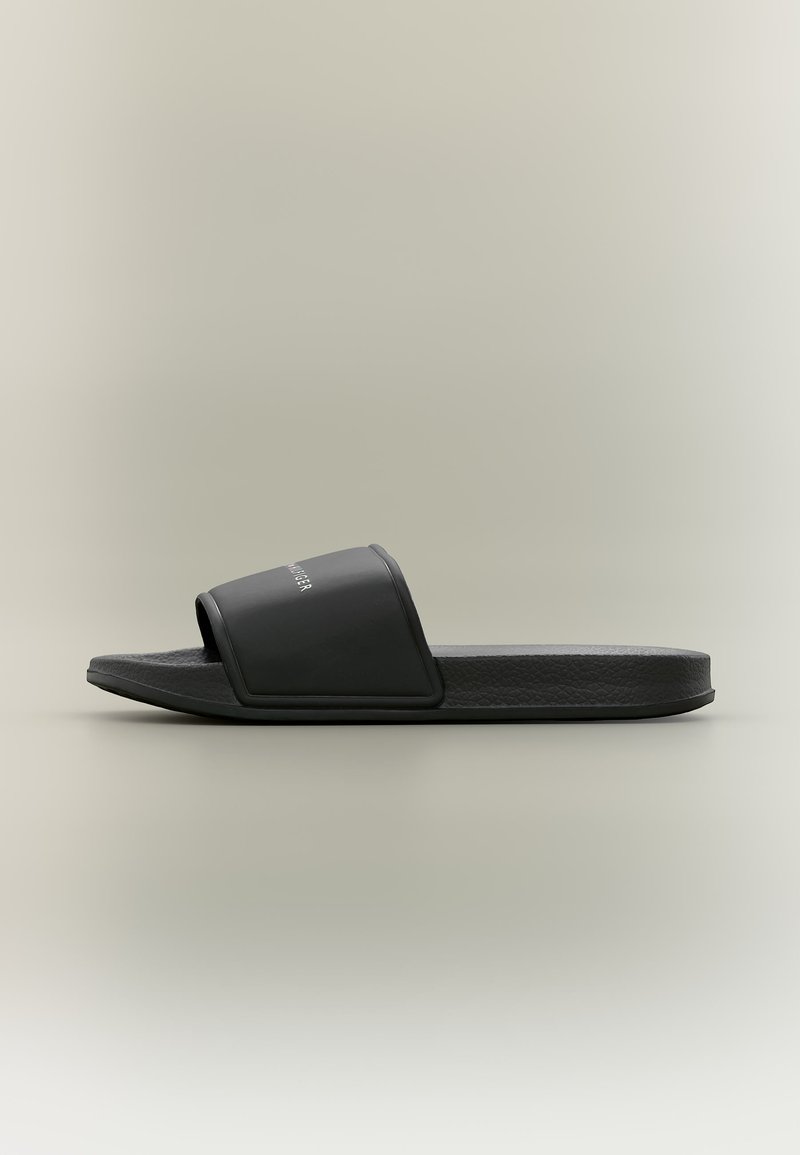 Μαύρο σανδάλι με λουράκι φαρδύ και υφή στην σόλα, πλάγια όψη σε ουδέτερο φόντο.