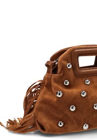 Bolso de ante marrón con asa rectangular recortada, tachuelas redondas plateadas y largas borlas de flecos sobre un fondo blanco.