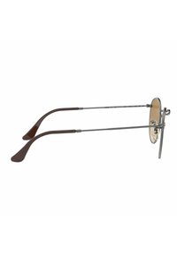 Occhiali da vista rotondi in metallo con lenti dorate, montatura argentata e aste in acetato marrone. Presentano linee eleganti e un design minimalista.