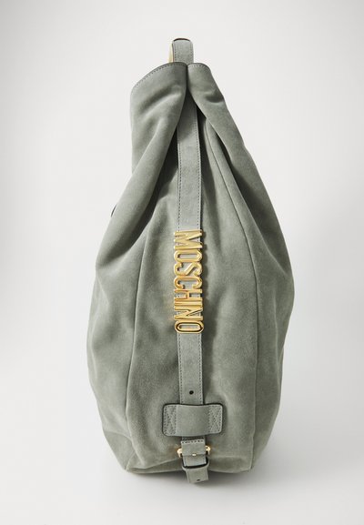 Grön mockaväska med en rynkad design, utrustad med en guld Moschino-logotyp och ett läderrem med spänne. Mjuk textur och elegant form.