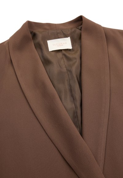 Brauner Blazer mit strukturierter Oberfläche, Satinfutter und einem "Slowear Montegro"-Etikett, das innen am Kragen angenäht ist.