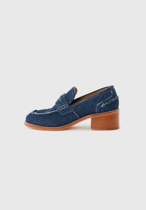 Women's denim loafer with a low block wooden heel, frayed edges, and a stitched strap detail across the upper.