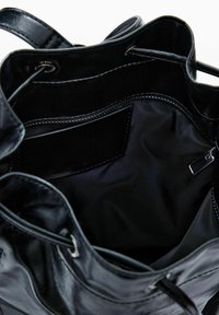 Fekete bőr vödrös táska, húzózsinórral záródik, nyitott belső térrel és egy cipzáros zsebbal.