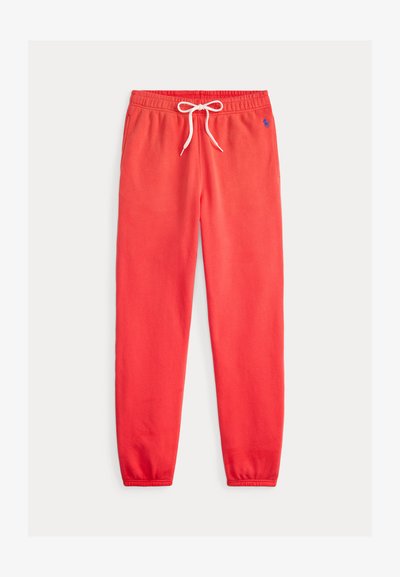 Czerwone spodnie dresowe z elastycznym pasem i białym sznurkiem, bocznymi kieszeniami, ściągaczami przy kostkach oraz małym niebieskim logo Polo na prawej biodrze.