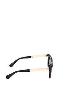 Sorte og guld briller med tekstureret sort frontramme og glatte sorte stænger, vist fra siden på en hvid baggrund.