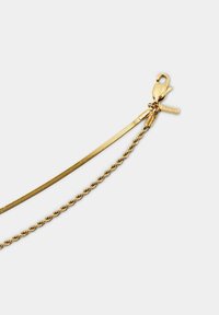 Gouden ketting met dubbele texturen: een gladde platte streng en een gedraaide uitvoering. Voorzien van een karabijnhaak en een tag gegraveerd met "ESPRIT."