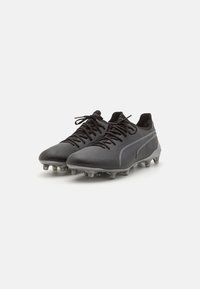 Botas de fútbol negras con un upper sintético suave, cierre de cordones y tacos moldeados en la suela para una mejor tracción. Sutiles acentos grises.