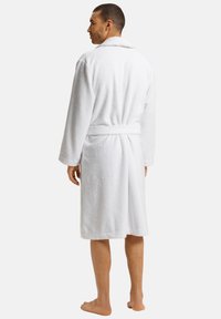 Hvid terrycloth badekåbe med lange ærmer, krave og bånd i taljen. Blød tekstur, knælængde, med et enkelt design.
