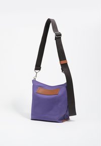 Fioletowa torba na ramię z brązowym skórzanym akcentem, regulowanym czarnym paskiem i przednią kieszenią. Gładka faktura i prostokątny kształt.