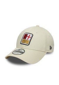 Beige cap made of fabric featuring a patch with red and black stripes and a cross. Includes a logo tag on the side and an adjustable fit.