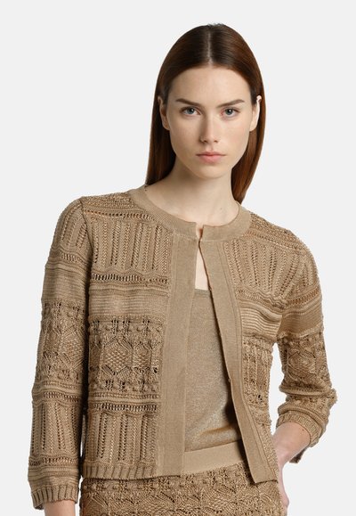 Beige kötött kardigán texturált dizájnal. Kerek nyakkivágással, nyitott elülettel és háromnegyedes ujjakkal rendelkezik. Az anyagnak finom fényessége van.