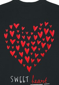 Črn material s srčno obliko, sestavljeno iz številnih rdečih vezenih srčkov različnih velikosti, spodaj pa besedilo "SWEET heart" v beli barvi.