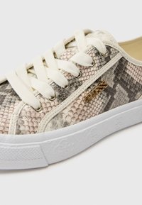 Baskets imprimées motif serpent, avec des tons beige et gris, des lacets blancs, des œillets en métal et une semelle blanche texturée avec détails logo.