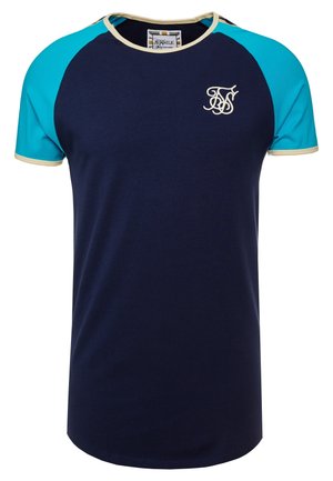 Granatowa koszulka z turkusowymi rękawami raglanowymi i kremowymi wykończeniami. Posiada naszyty logo na piersi. Gładki bawełniany materiał.