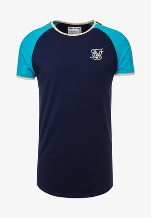 Marineblaues T-Shirt mit türkisfarbenen Raglanärmeln und cremefarbener Borte. Enthält ein besticktes Logo auf der Brust. Glattes Baumwollgewebe.