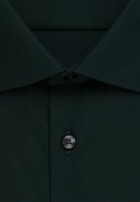 Donkergroen overhemd met knopen, voorzien van een klassieke kraag, een enkele zwarte knoop op de knoopsluiting en een glad, gestructureerd stof.