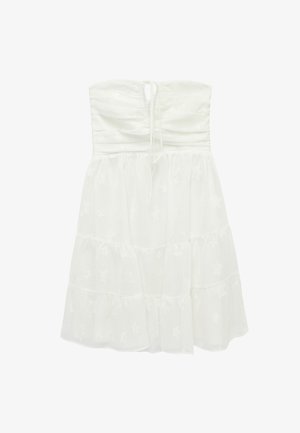 Robe blanche sans bretelles avec corsage froncé, jupe à volants et motifs subtils d'étoiles sur l'ensemble du tissu.
