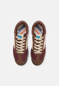 Zapatillas deportivas con un upper de ante marrón y tejido burdeos, cordones crema y una plantilla multicolor con rayas. Suela de goma.