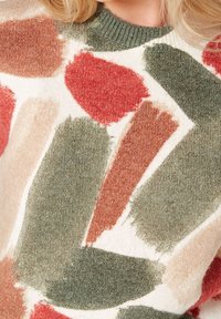 Knit sweater featuring a cream base with abstract brushstroke patterns in earthy tones: red, green, and beige; round neckline with ribbed trim.