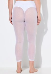 Leggings blancs et transparents avec un motif en diamant, taille haute et longueur cheville. Le tissu semble léger avec une texture lisse.