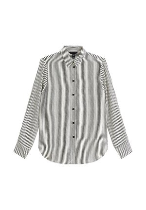 Biała koszula z długim rękawem w czarne pionowe paski, zapinana na guziki z przodu, z ostro zakończonym kołnierzykiem, ułożona na płasko na białym tle.