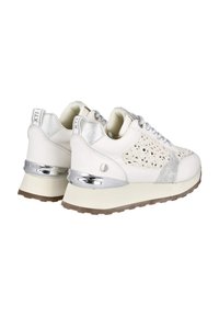 Zapatillas blancas con acentos plateados, incluyendo un diseño perforado, cuero suave y una suela gruesa con un detalle de tacón brillante.