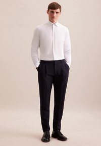 Weißes Hemd mit Knöpfen, dunkle plissierte Hose, schwarze elegante Schuhe. Glatter Stoff, maßgeschneiderte Passform, klassischer Kragen. Einfaches, modernes Design.