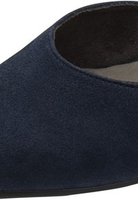 Gros plan d'une pantoufle en daim bleu marine avec un bout arrondi et une doublure intérieure noire douce.