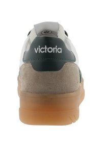 Sneaker bianca con accenti verde e grigio, texture in suede al tallone e suola in gomma traslucida. Logo "Victoria" sul retro.