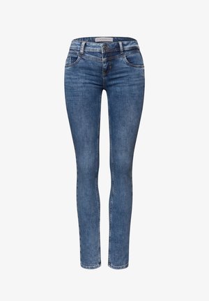 Blue denim skinny jeans with a mid-rise waist, belt loops, front pockets, and subtle stitching details. Smooth texture, classic design.