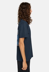 Navyblauwe katoenen t-shirt met korte mouwen, relaxte pasvorm, met een grafisch ontwerp op de achterkant en ronde hals. Zachte textuur.