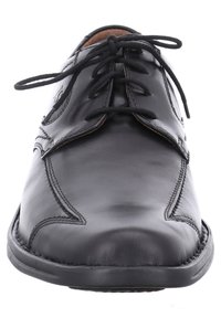 Musta nahkakengät nauhoilla, joissa on pyöreä kärki, näkyvät ompeluyksityiskohdat ja sileä tekstuuri. Klassinen muotoilu ja vähäinen varustelu.