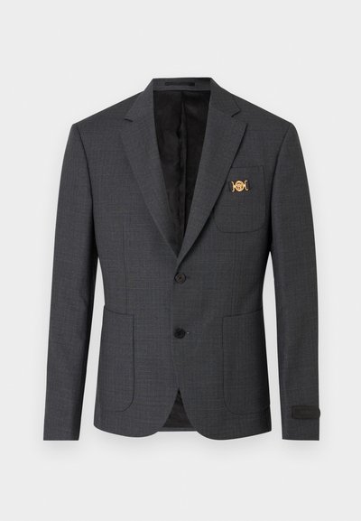 Blazer gris foncé ajusté avec deux poches avant à rabat, deux boutons noirs, col à encoches et épingle décorative dorée sur la poche poitrine.