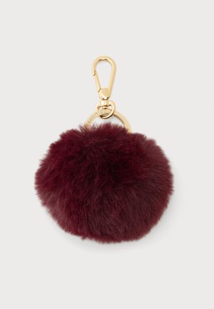 Bordeaux-farvet fluffy pompom-nøglering med en rund guldring og en guldlobsterlås på en lys baggrund.
