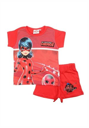 Pigiama rosso per bambini con una stampa grafica di un personaggio, maniche corte e pantaloni corti abbinati con un accentuato logo. Tessuto morbido.