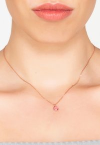 Rózsaarany nyaklánc finom lánccal és csepp alakú rózsaszín drágakő medállal, sima felülettel és diszkrét fényléssel.