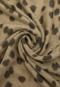 Lekki materiał w odcieniu beżu z ciemnozielonymi i czarnymi plamami w leopardzie, o miękkiej strukturze i zwiewnym, spiralnym wzorze.