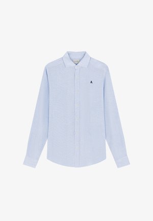 Camisa de manga larga azul claro con botones, cuello y pequeño logotipo bordado en negro de calavera en el lado izquierdo del pecho.