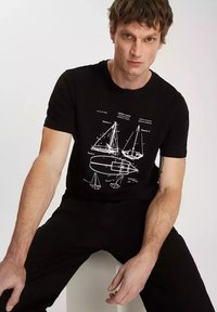 Czarna koszulka z bawełny z białym nadrukiem w stylu marynistycznym, przedstawiająca żaglówki i diagramy. Krótkie rękawy i klasyczny krój.