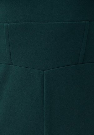 Dark green fabric featuring a smooth, textured surface with a structured design, including a rectangular pocket detail on the back.