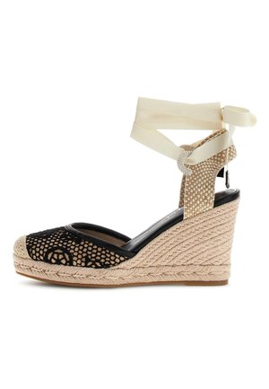 Sandale compensée espadrille avec talon tressé beige, bout en mesh noir, et ruban crème noué autour de la cheville.