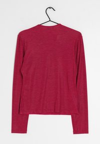 Langærmet skjorte i en ensfarvet fuchsia farve, lavet af letvægtsstof med en glat tekstur. Har en rund halsudskæring og en ophængsløkke.