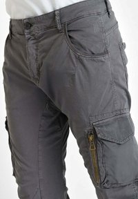 Grijze cargobroek van een katoenmix. Heeft meerdere zakken, waaronder een met rits en zichtbare stikselaccenten.