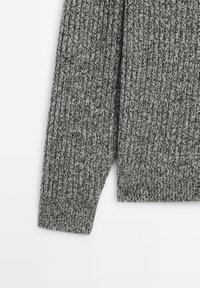 Gray knitted sweater featuring a ribbed texture, with long sleeves and a rounded hem. The fabric displays a subtle blend of dark and light threads.