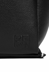 Borsa in pelle nera con superficie testurizzata. Presenta logo embossato sulla parte anteriore, bordi ben definiti e accenti bianchi alla base.