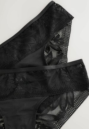 Zwarte onderkleding gemaakt van gladde stof met bloemrijke kanten accenten. Beschikt over een combinatie van effen en doorschijnende materialen in een gelaagd ontwerp.