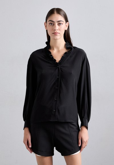 Black button-up shirt with a ruffled collar and long sleeves. Made from a smooth fabric, featuring a relaxed fit and subtle sheen.