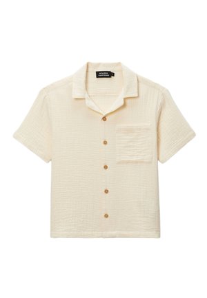 Chemise à manches courtes couleur crème, en tissu texturé, avec une poche poitrine et cinq boutons marron, présentant un design de col classique.