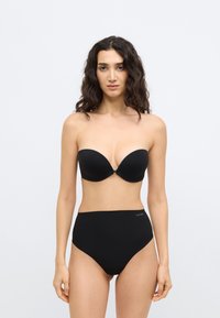 Μαύρο σουτιέν χωρίς τιράντες με λείες θήκες και κεντρικό κούμπωμα, σετ με ψηλόμεσο μαύρο σλιπ που διαθέτει διακριτικό λογότυπο στη μέση.