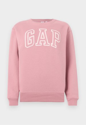 Sweat-shirt rose à col rond avec poignets et ourlet côtelés, présentant de grandes lettres "GAP" blanches en contour sur la poitrine.